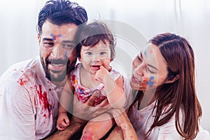 Mixed race family concept. Happy family playing multi color by put to their faces and body with smile and laughing together.