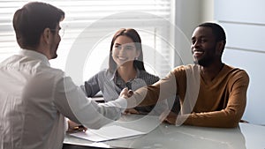 Smiling african american satisfied client shaking hands with salesman.