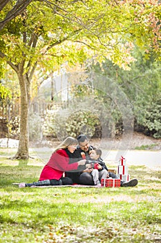 Mixed Race Family Enjoying Christmas Gifts in Park