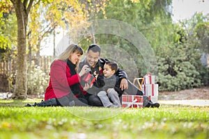 Mixed Race Family Enjoying Christmas Gifts in the Park Together