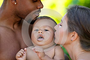 Mixed race family outdoor portrait. Mixed race parents with baby child on nature. Mixed race Portrait of happy african