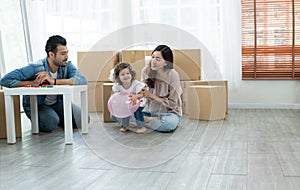 Mixed race family playing balloon together. Young Caucasian father with beard and Asian mother playing blocks toy and blow balloon