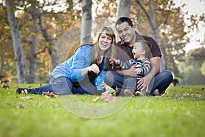 Mixed Race Family Playing with Bubbles In Park