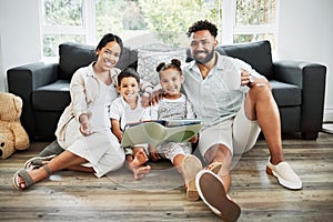 Mixed race family reading a book together on the floor at home. Hispanic mother and father teaching their little son and