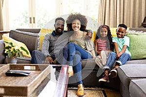 Mixed race family spending time together sitting on a couch