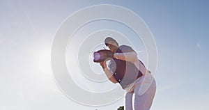 Mixed race female baseball fielder catching and throwing ball on sunny baseball field