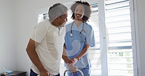 Mixed race female doctor home visiting helping senior patient get up