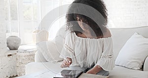 Mixed race female freelance artist using digital tablet with electronic pencil to create crypto art or drawing