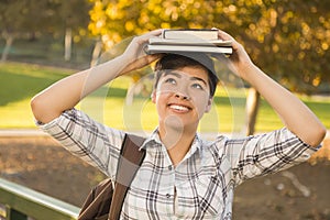 Mixed Race Female Student Holding Books on Her Head