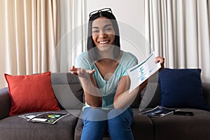 Mixed race gender fluid man working at home making video call holding documents and smiling photo