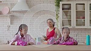 Mixed race kids helping mom doing household chores