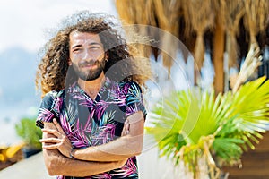 mixed race man with curly long hair outdoors ar sunny day