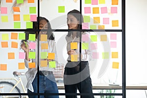 Mixed race managers working together near kanban board. photo