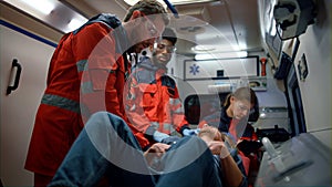 Mixed race medical team giving first aid help in ambulance car