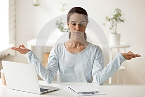 Mixed race mindful female employee doing breathing yoga exercises.