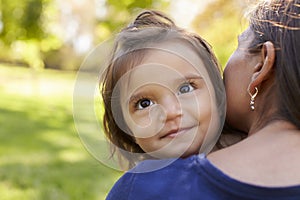 Mixed race mother holding her daughter, over shoulder view