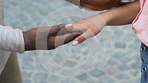 Mixed-race relations, afro-american man stroking hands of Caucasian woman