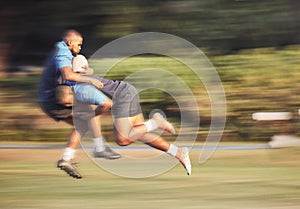 Mixed race rugby player attempting to tackle an opponent during a rugby match outside on the field. Young hispanic man