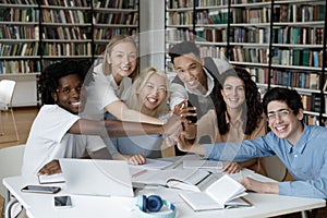 Mixed race team of happy students giving group high five