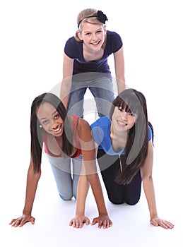 Mixed race teenage girl friends in fun pyramid