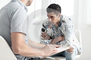 Mixed-race teenager struggling with alcohol addiction talking to photo