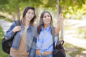 Mixed Race Twin Sisters Wearing Backpacks and Pointing Outside