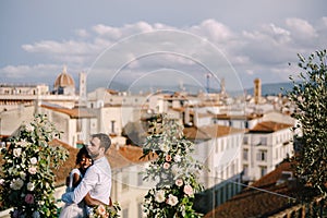 Mixed-race wedding couple. Destination fine-art wedding in Florence, Italy. A wedding ceremony on the roof of the