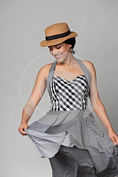 Mixed race woman in chequered summer dress and canotier straw hat