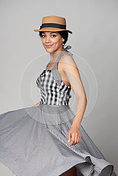 Mixed race woman in chequered summer dress and canotier straw hat