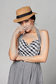 Mixed race woman in chequered summer dress and canotier straw hat