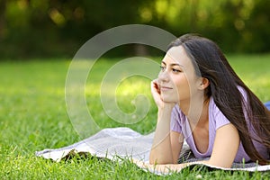 Mixed race woman contemplating on the grass in a park