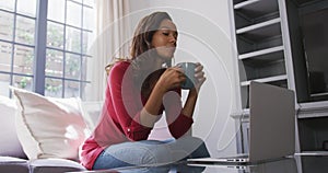 Mixed race woman enjoying drinking tea. Social distancing and self isolation in quarantine