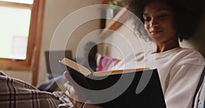 Mixed race woman reading in the living room