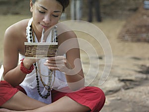 Mixed Race Woman Reading Postcard Outdoors