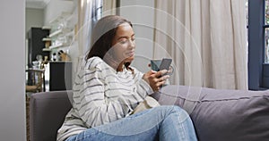 Mixed race woman using a smartphone. Social distancing and self isolation in quarantine