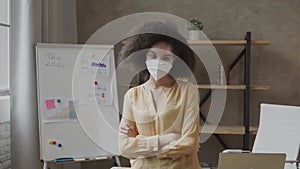 Mixed-race woman wearing protective medical mask in the office. Precautionary measures for office employees during
