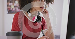 Mixed race woman working on computer in creative office