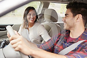 Mixed race young couple smiling in a car on a road trip