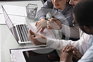 Mixed race young coworkers employees discussing project report.