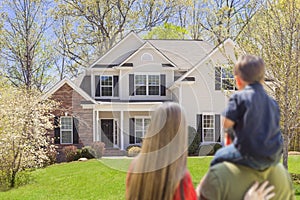 Mixed Race Young Family Looking At Beautiful Home