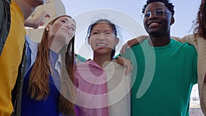 Mixed-race young people having fun together embracing each other outdoor.