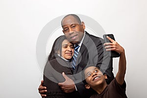 Mixed Raced Couple Posing for Photo and Son Taking Selfie with Smart Phone