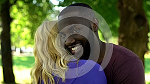 Mixed raced happy couple, black man embracing woman, interracial relationship