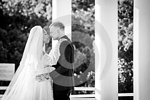 Mixed-racial newlyweds on a walk hugging and looking lovingly at each other, black and white photography