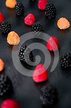 Mixed of red, black, yellow raspberries on table. Close up.