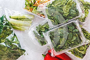 Mixed salad and baby spinach in plastic food bag and plastic container