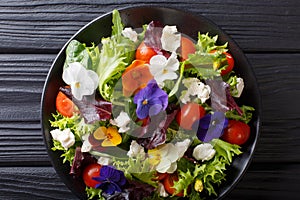 Mixed salad of edible flowers with lettuce, tomatoes and cream c