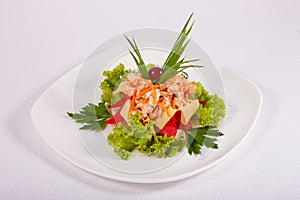 Mixed salad with greens, tomatoes, carrots, pasta in white plate