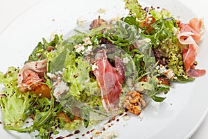 Mixed salad with herbs, prosciutto and parmesan.
