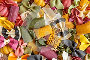 Mixed selection of dried pasta on wooden background. Macaroni scattered on a glass jar. Background. Close up